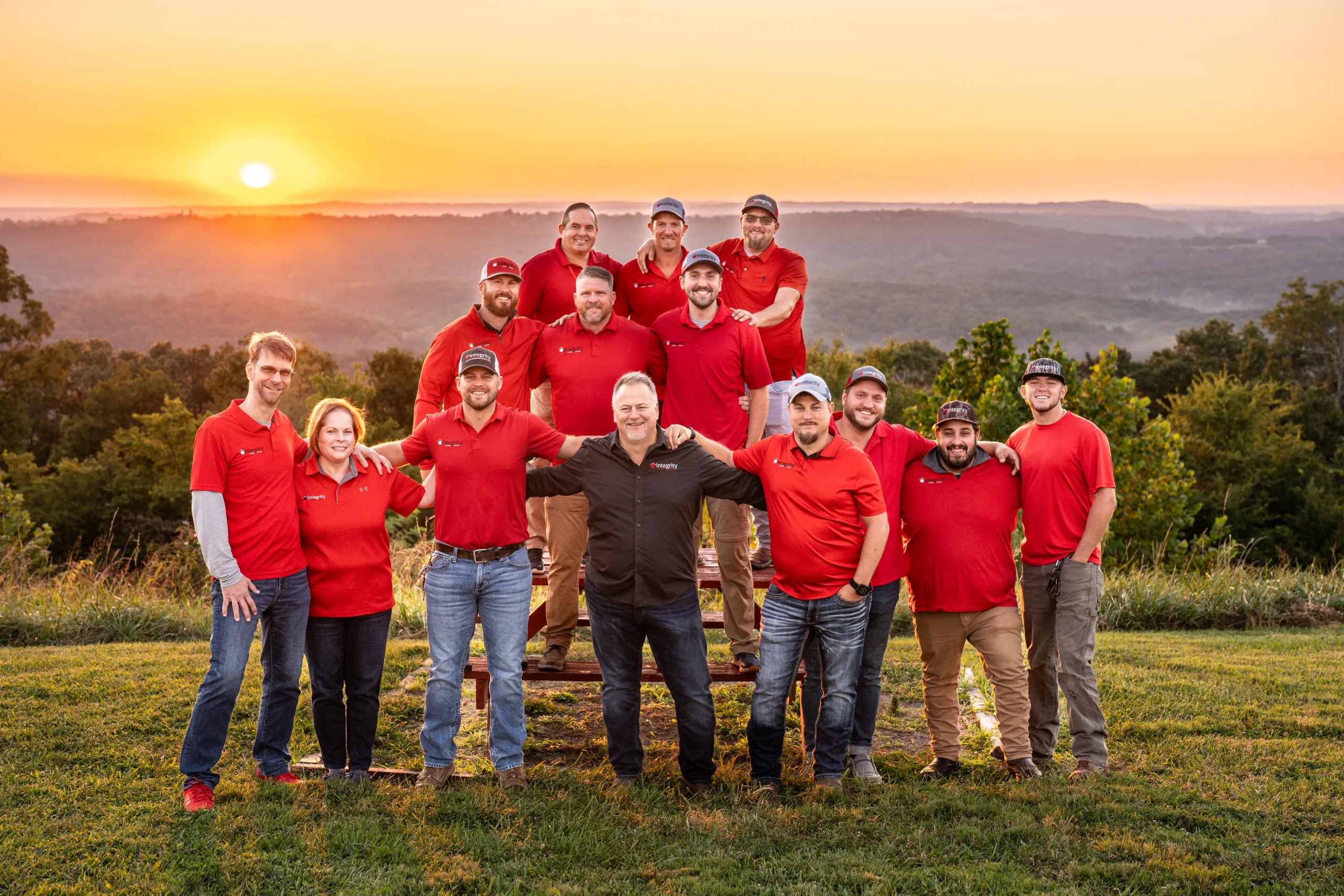 Integrity Roofing & Exteriors team posing together outdoors at sunset